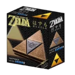 Кутия за пъзел Triforce от Zelda. Кутията е предимно черна с акценти в златисто и бронзово. Изображението на кутията показва пъзела Triforce като трите триъгълни части са подредени така че да образуват по-голям триъгълник. Частите са в тъмно бронзов цвят с леко износен или текстуриран завършек. Логото ZELDA е изписано с големи златни букви. Кутията съдържа и японски текст вероятно инструкции или преводи на името на играта разположен подходящо в дизайна. TRIFORCE и LEVEL са изписани със златен текст като до тях има малки символи свързани с тях. Дизайнът е чист директен и тематично свързан с популярната видеоигра. Перспективата е леко наклонена показваща почти всички страни на кутията. Композицията е симетрична съсредоточена върху централното изображение на пъзела Triforce. Осветлението е равномерно без силни светлини или сенки с ясни детайли по целия дизайн. Атмосферата е игрива и съсредоточена върху елементите на бранда на играта.